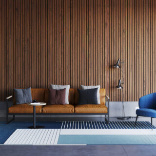 A modern living room design featuring Ezobord Balsa acoustic wall panels, a leather sofa, blue armchair, and geometric rug, creating a visually appealing space.