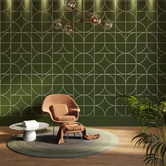 A green Ezobord Carve acoustic wall panel with a geometric pattern, featuring a leather armchair, coffee table, and houseplants.