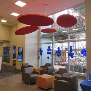Red Ezobord acoustic baffles suspended from the ceiling in a bank lobby.